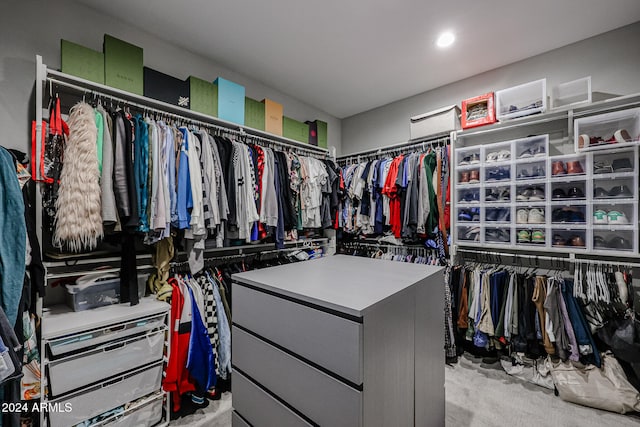 walk in closet with light carpet