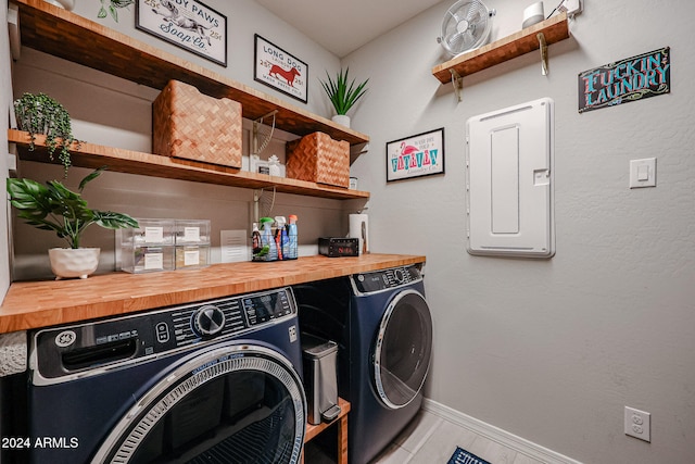 washroom featuring electric panel, separate washer and dryer, and light tile patterned floors