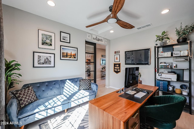 home office with light hardwood / wood-style flooring and ceiling fan