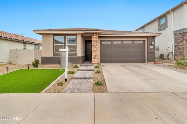 prairie-style home featuring stucco siding, an attached garage, a front yard, fence, and driveway