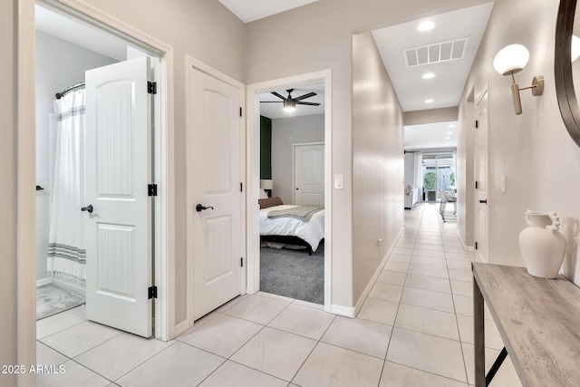 hallway with recessed lighting, baseboards, visible vents, and light tile patterned flooring