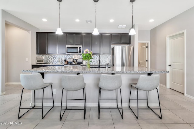 kitchen featuring light tile patterned floors, tasteful backsplash, visible vents, a large island, and appliances with stainless steel finishes