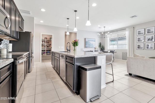 kitchen featuring light tile patterned floors, appliances with stainless steel finishes, a sink, and visible vents