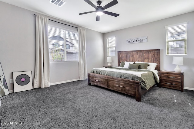 carpeted bedroom with baseboards, multiple windows, visible vents, and a ceiling fan