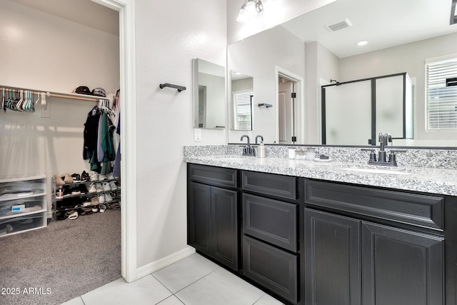 bathroom with a stall shower, visible vents, a sink, and double vanity