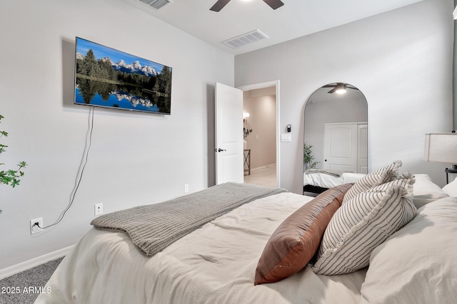 bedroom with a ceiling fan, arched walkways, visible vents, and baseboards