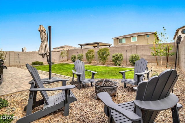 view of yard featuring a patio area, a fenced backyard, and a fire pit