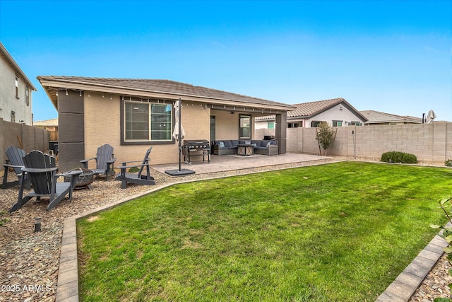 back of house featuring a patio, a fenced backyard, an outdoor living space with a fire pit, and stucco siding