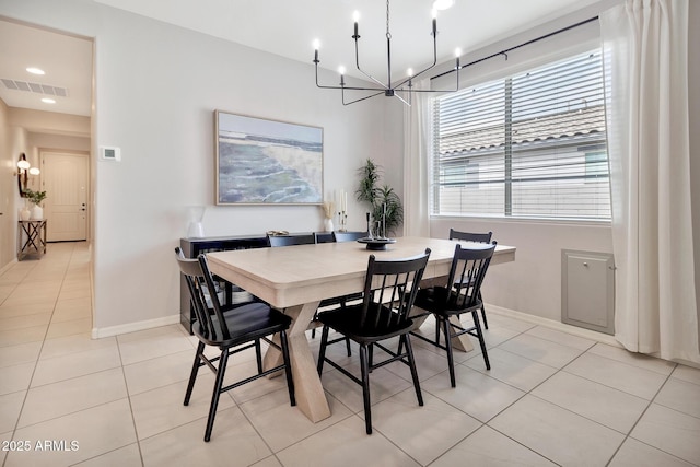 dining space with light tile patterned floors, visible vents, baseboards, and a notable chandelier