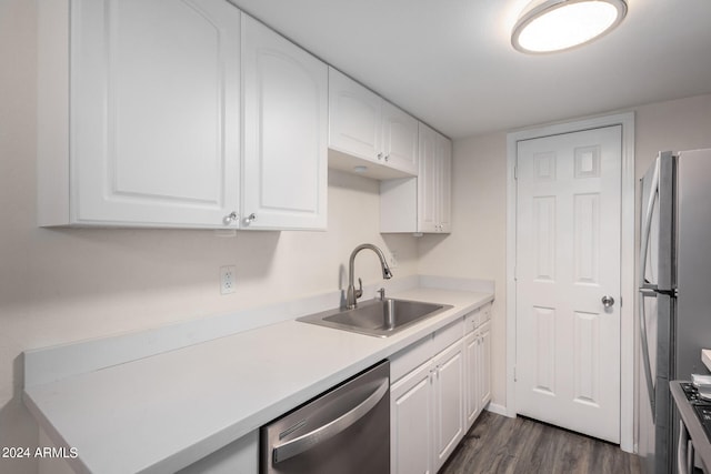 kitchen with sink, dark wood-type flooring, stainless steel appliances, and white cabinets