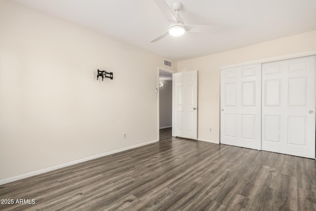 unfurnished bedroom with ceiling fan, dark hardwood / wood-style flooring, and a closet