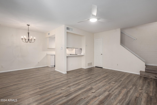 unfurnished living room featuring dark hardwood / wood-style floors and ceiling fan with notable chandelier