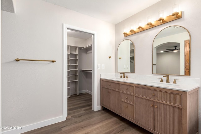 bathroom featuring double vanity, wood finished floors, and a sink