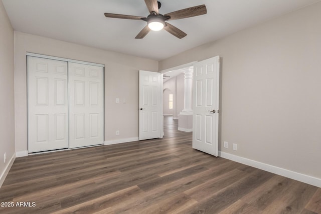 unfurnished bedroom with a ceiling fan, baseboards, dark wood-style flooring, and a closet