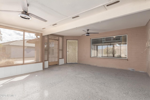 unfurnished sunroom with ceiling fan