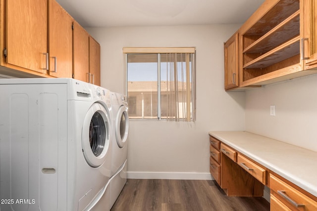 clothes washing area with washer and dryer, baseboards, cabinet space, and dark wood finished floors