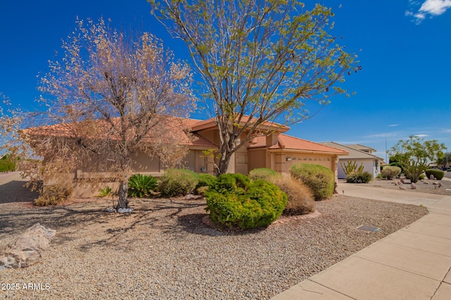 view of front of house featuring a garage, stucco siding, driveway, and a tile roof