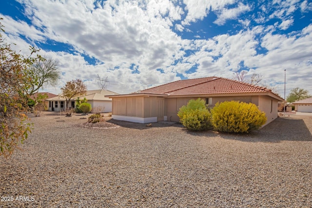 view of side of home with a tile roof, a sunroom, and stucco siding