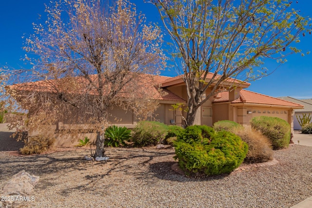 view of front of property featuring a garage, stucco siding, and a tile roof