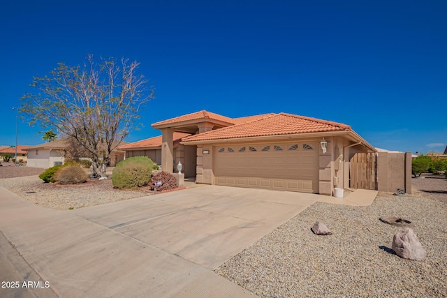 view of front of property with stucco siding, a garage, driveway, and a tile roof