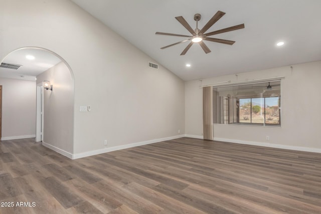 unfurnished room with arched walkways, visible vents, a ceiling fan, and wood finished floors