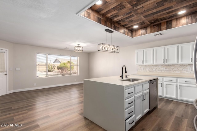 kitchen featuring stainless steel dishwasher, dark wood-type flooring, baseboards, and a sink