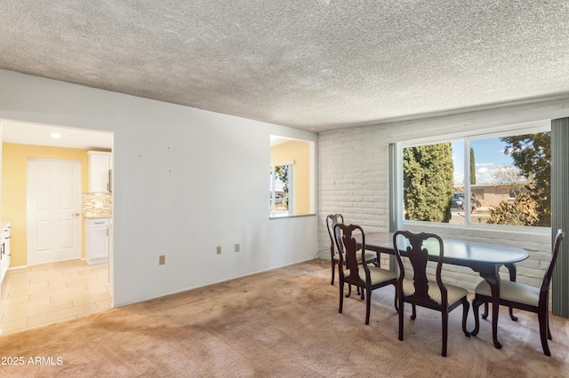 dining room featuring light carpet, a textured ceiling, and light tile patterned flooring