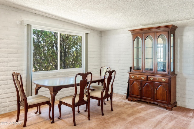 dining room featuring light carpet, brick wall, a textured ceiling, and vaulted ceiling