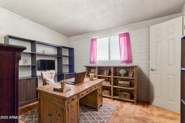 office featuring lofted ceiling, brick wall, and a textured ceiling