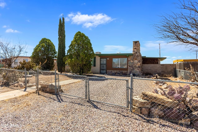 view of front of home with a gate, stone siding, and a fenced front yard