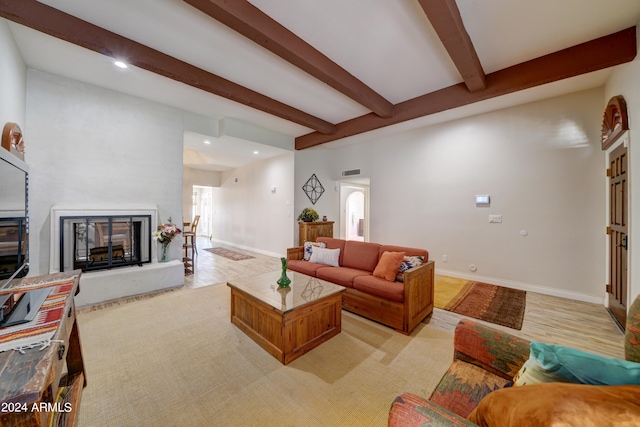 living room featuring beam ceiling and light hardwood / wood-style floors