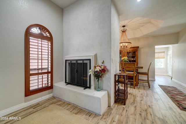 living room featuring a notable chandelier, plenty of natural light, and light hardwood / wood-style floors