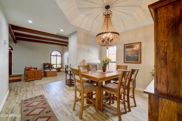 dining room featuring an inviting chandelier, light wood-type flooring, and beamed ceiling