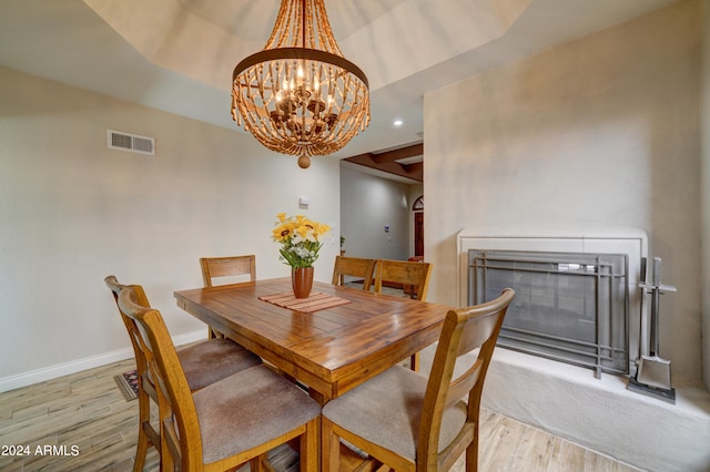 dining area with a notable chandelier and light hardwood / wood-style floors