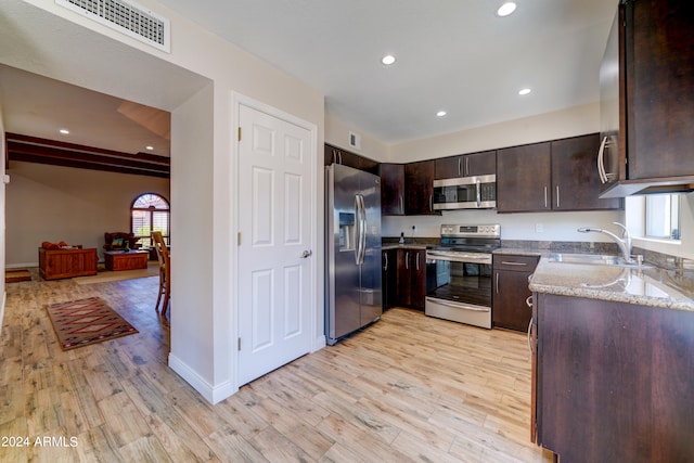 kitchen featuring dark brown cabinets, appliances with stainless steel finishes, sink, and light hardwood / wood-style flooring