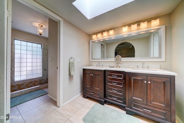 bathroom with vanity, a skylight, a shower with shower door, and tile patterned floors