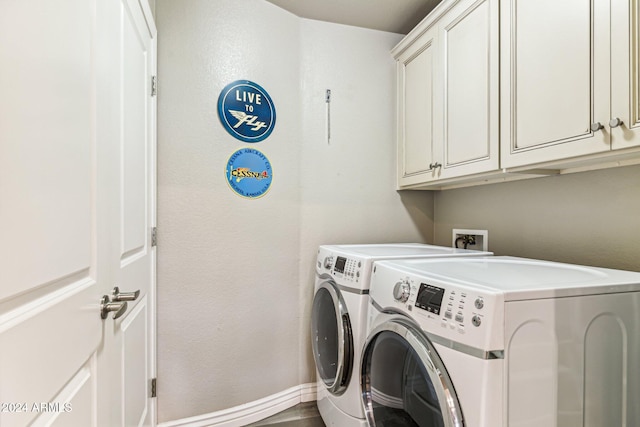 clothes washing area featuring separate washer and dryer and cabinets