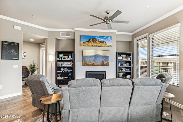 living room with light wood-type flooring, ceiling fan, and ornamental molding