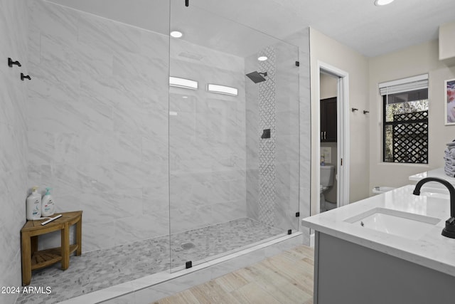 bathroom with vanity, toilet, and a tile shower