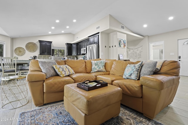 living room featuring vaulted ceiling and light hardwood / wood-style floors