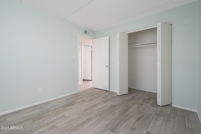 unfurnished bedroom featuring a closet and light hardwood / wood-style flooring