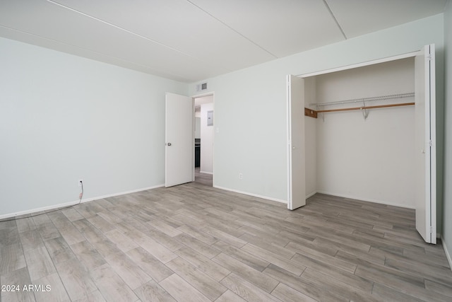 unfurnished bedroom with hardwood / wood-style floors and a closet