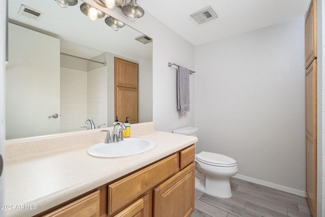 bathroom with wood-type flooring, vanity, and toilet