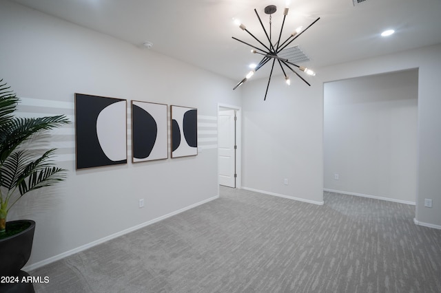 spare room with carpet flooring and an inviting chandelier