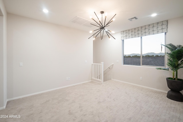 empty room with a notable chandelier and light carpet