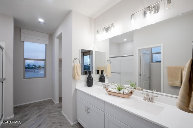 bathroom with parquet flooring, vanity, plenty of natural light, and an enclosed shower