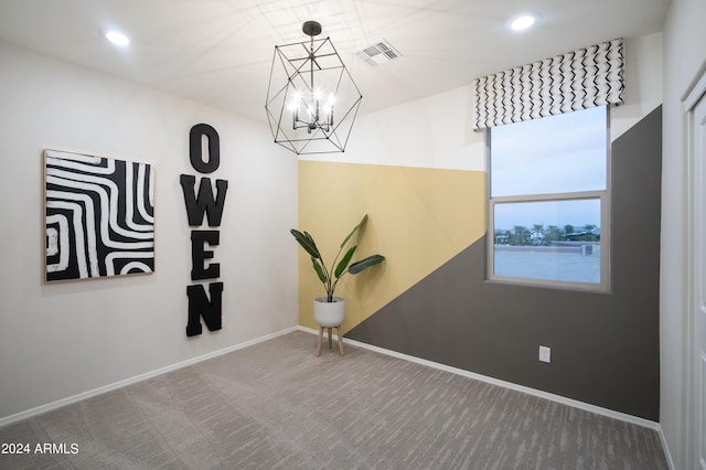 spare room featuring carpet and a chandelier