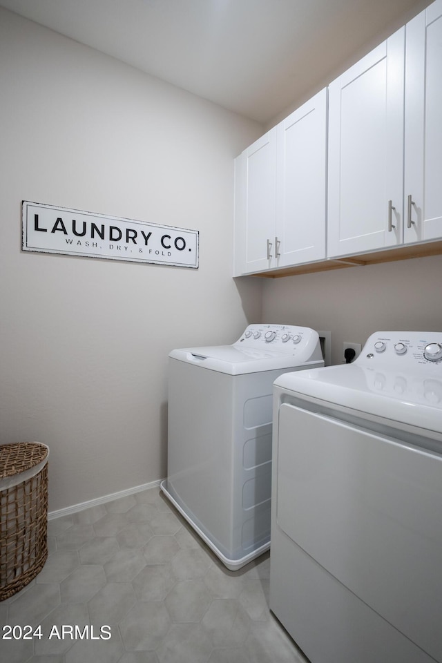 washroom with cabinets and washing machine and clothes dryer