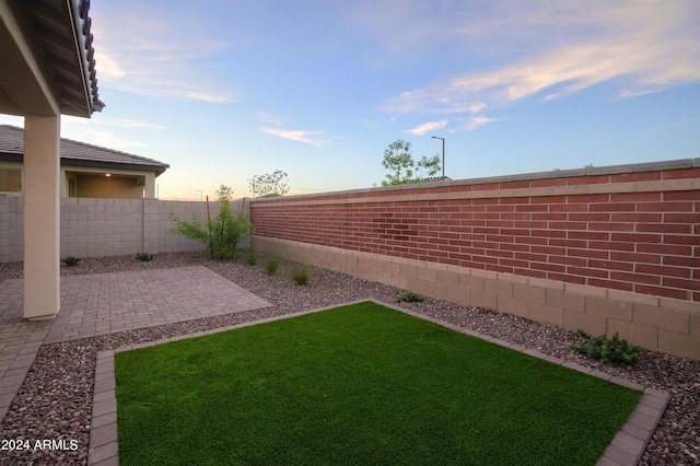 yard at dusk with a patio area