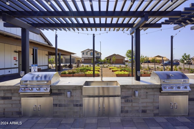 view of patio featuring a pergola, exterior kitchen, and grilling area